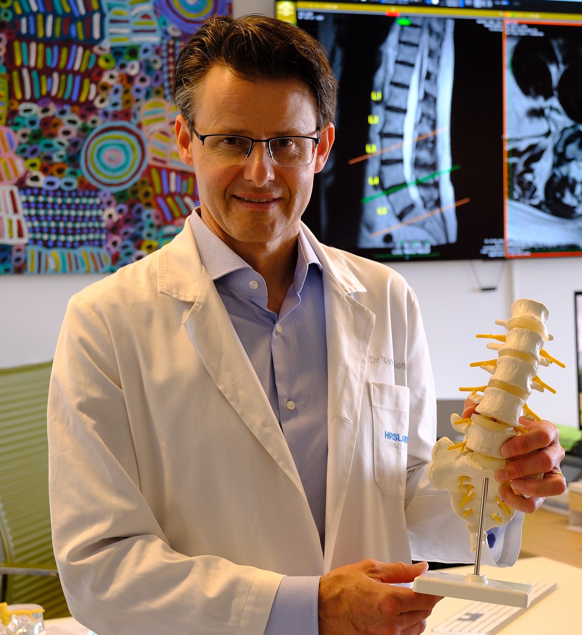 Dr Benoit Jenny at the practice with a spine model